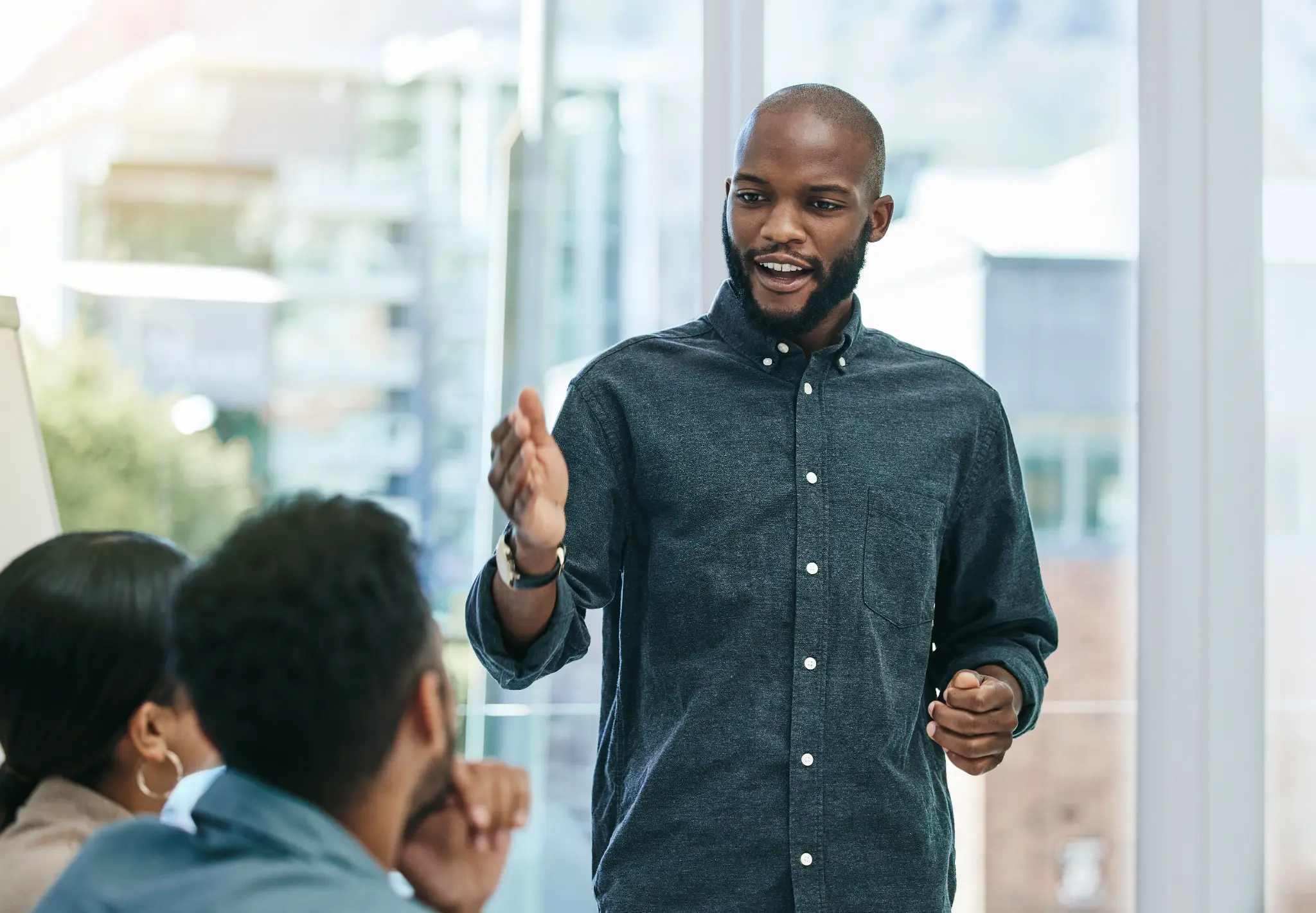 Man leading a discussion with colleagues in a bright office meeting