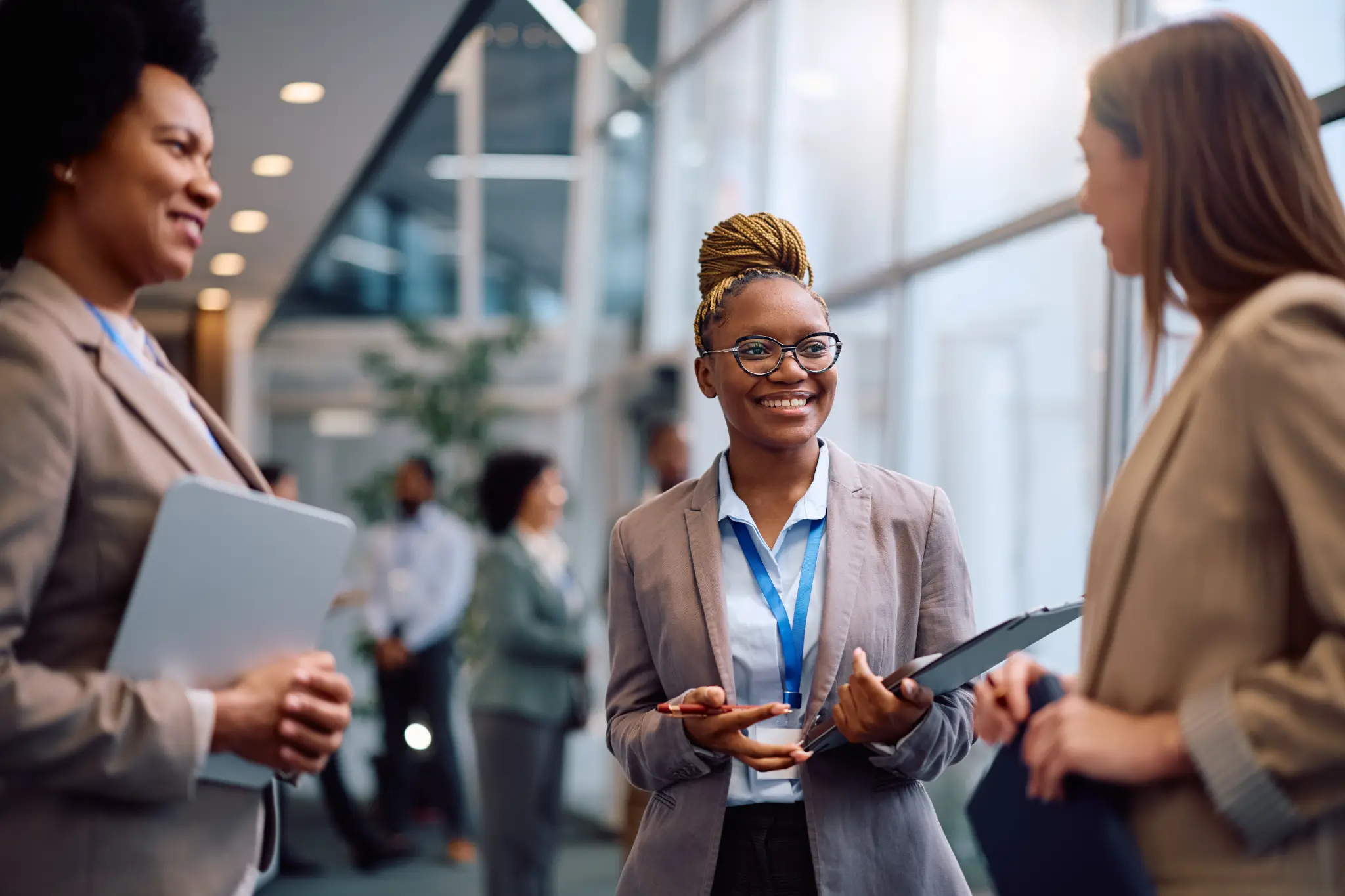 Three businesswomen sharing a conversation in a bright professional setting